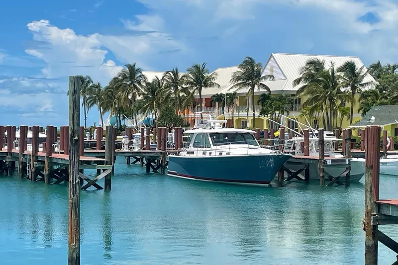  Yacht Photos Pics 2022 Sabre 45 Salon Express yacht docked at a tropical marina with palm trees.