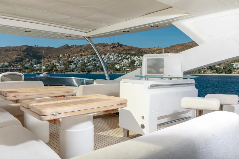 Merci Yacht Photos Pics Luxurious Sunseeker 88 Yacht 2010 with elegant outdoor seating and scenic coastal view.
