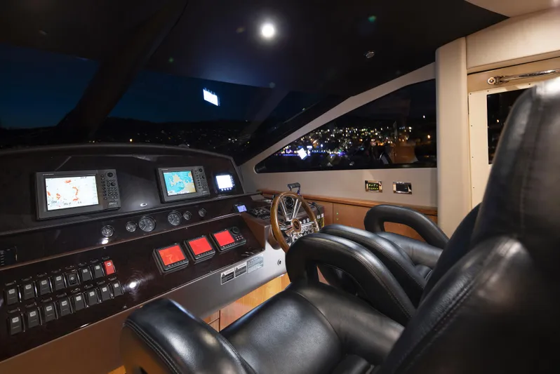 Merci Yacht Photos Pics Cockpit of 2010 Sunseeker 88 Yacht with navigation screens and leather seats at night.