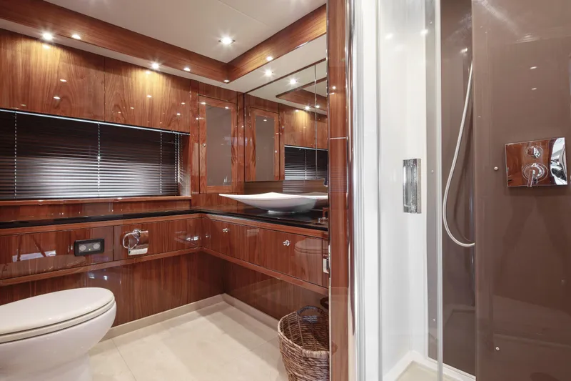 Merci Yacht Photos Pics Luxurious bathroom on a 2010 Sunseeker 88 Yacht with wood paneling and modern fixtures.