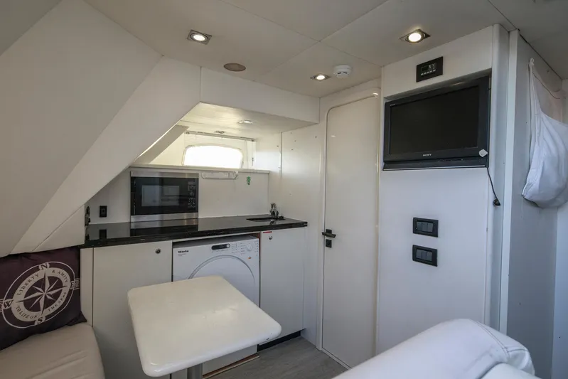 Merci Yacht Photos Pics Interior of 2010 Sunseeker 88 Yacht with modern kitchenette and seating area.