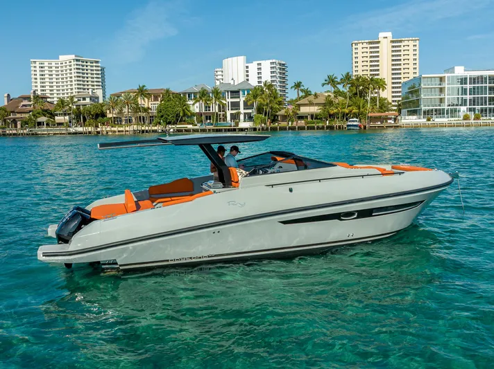  Yacht Photos Pics 2024 Rio Yachts Daytona 35 cruising on clear blue water near urban skyline.
