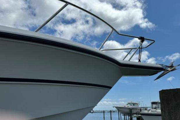 1992 Stamas 288 Liberty boat docked under a blue sky with clouds.