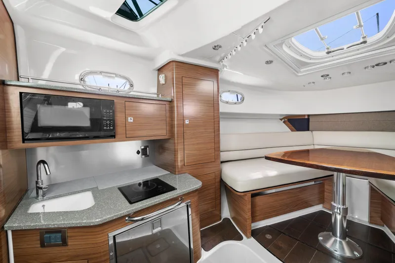  Yacht Photos Pics 2017 Boston Whaler 345 Conquest Pilothouse interior with kitchenette and dining area.
