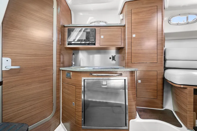  Yacht Photos Pics 2017 Boston Whaler 345 Conquest Pilothouse interior kitchen with microwave and stainless steel appliances.