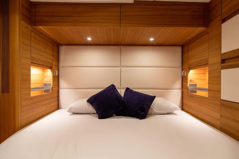  Yacht Photos Pics Luxurious bedroom interior of 2026 Ice Yachts 70, featuring wood paneling and plush bedding.