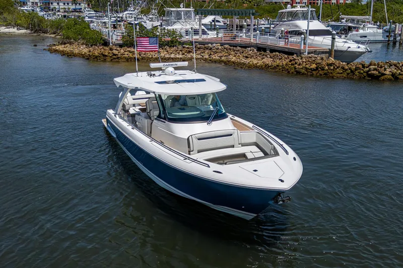 Let It Ride Yacht Photos Pics 2024 Tiara Yachts 38 LS cruising in a marina, showcasing sleek design and luxury features.