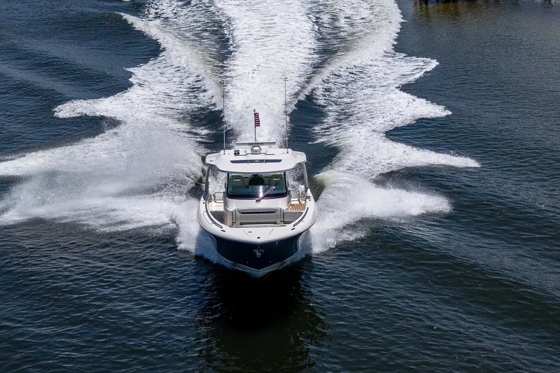 Let It Ride Yacht Photos Pics 2024 Tiara Yachts 38 LS cruising on water, creating dynamic wake patterns.