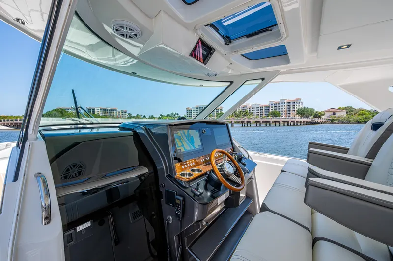 Let It Ride Yacht Photos Pics 2024 Tiara Yachts 38 LS helm with modern controls, luxurious seating, and waterfront view.