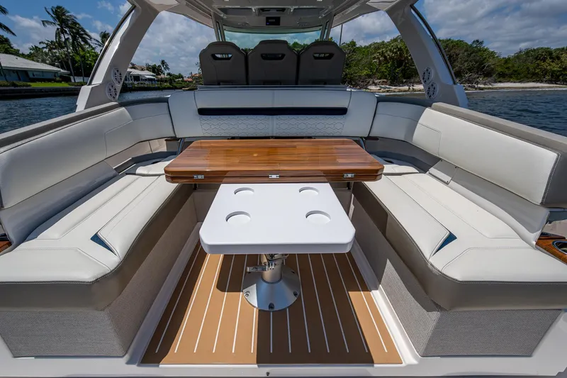 Let It Ride Yacht Photos Pics 2024 Tiara Yachts 38 LS interior with elegant seating and wooden table on a sunny day.