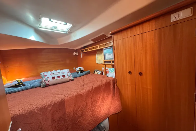 Wayward Sun Yacht Photos Pics Cozy cabin interior of 2000 Lagoon 380 catamaran with wood paneling and skylight.