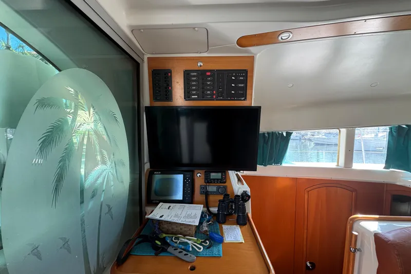 Wayward Sun Yacht Photos Pics Interior of 2000 Lagoon 380 catamaran with navigation equipment and palm tree window design.