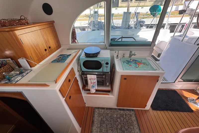 Wayward Sun Yacht Photos Pics Interior of 2000 Lagoon 380 catamaran kitchen with wooden cabinets and modern appliances.