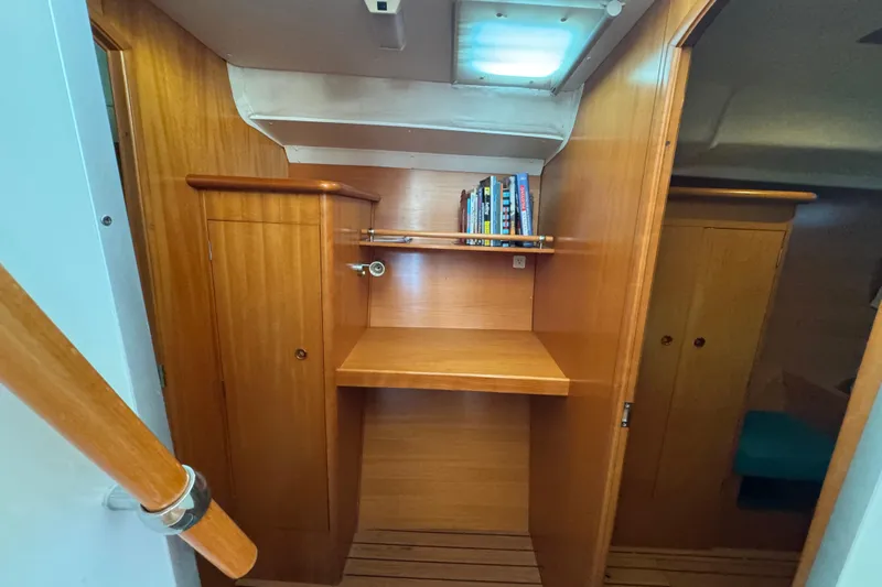 Wayward Sun Yacht Photos Pics Interior of 2000 Lagoon 380 catamaran with wooden cabinetry and books on a shelf.