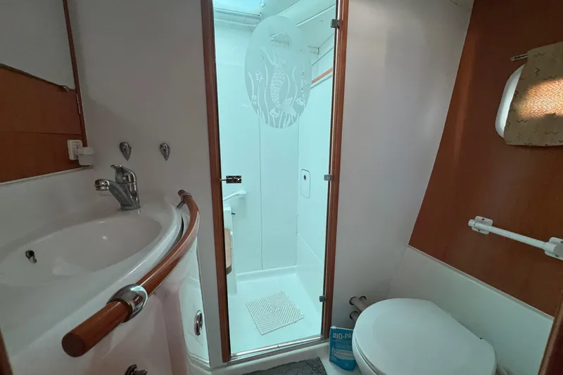 Wayward Sun Yacht Photos Pics Bathroom interior of 2000 Lagoon 380 catamaran with sink, shower, and toilet.