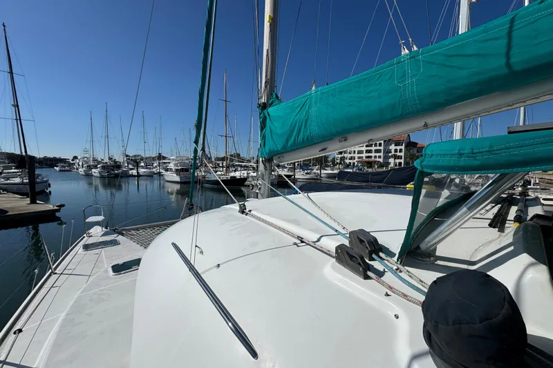 Wayward Sun Yacht Photos Pics Lagoon 380 catamaran from 2000 docked in a marina under clear blue skies.