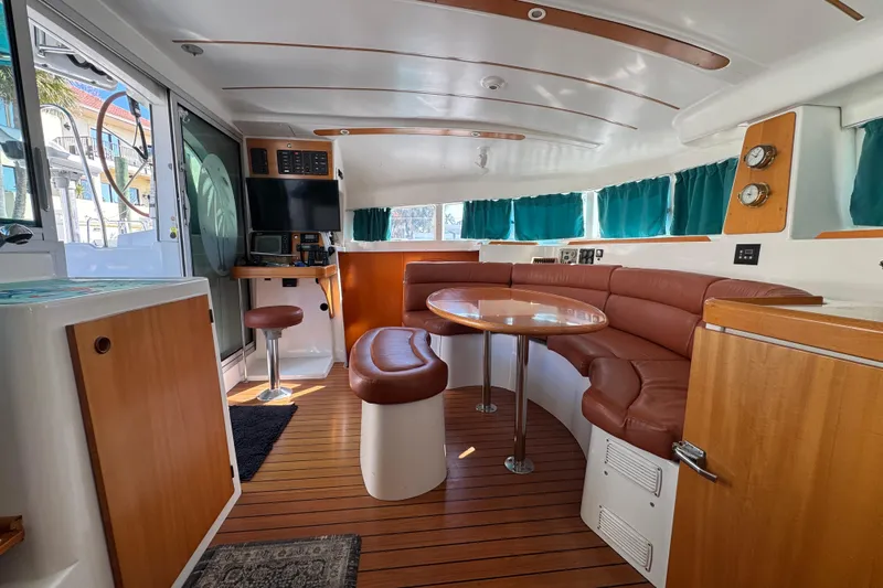 Wayward Sun Yacht Photos Pics Interior of 2000 Lagoon 380 catamaran with wood accents and leather seating.