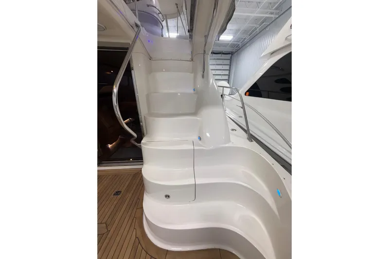  Yacht Photos Pics Staircase on 2001 Sea Ray 560 Sedan Bridge yacht, featuring sleek white design and wooden deck.