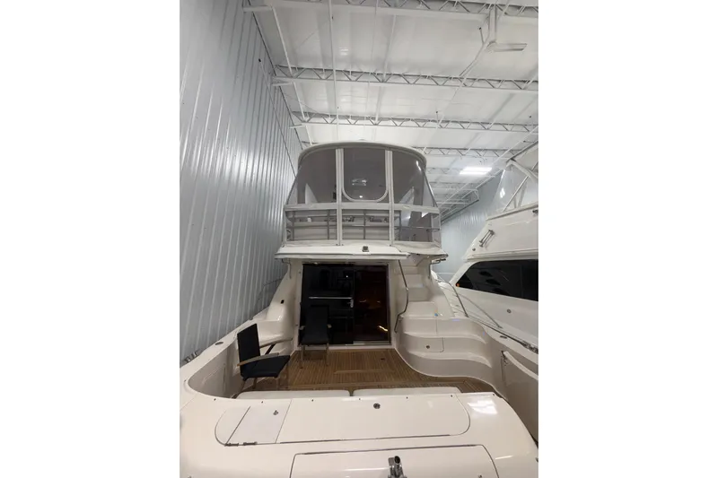  Yacht Photos Pics 2001 Sea Ray 560 Sedan Bridge yacht in indoor storage, showcasing rear deck and upper bridge.