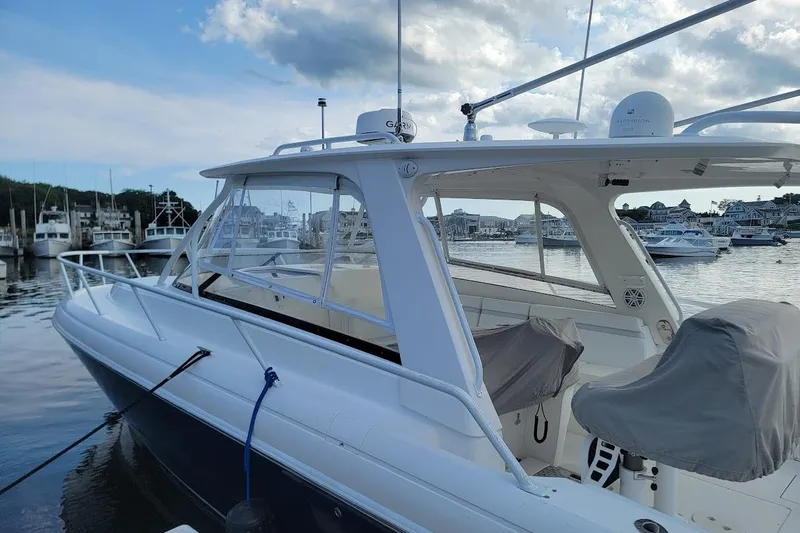  Yacht Photos Pics 2010 Intrepid 39 Kevlar Hull Sport Yacht docked at marina, featuring sleek design and covered seats.