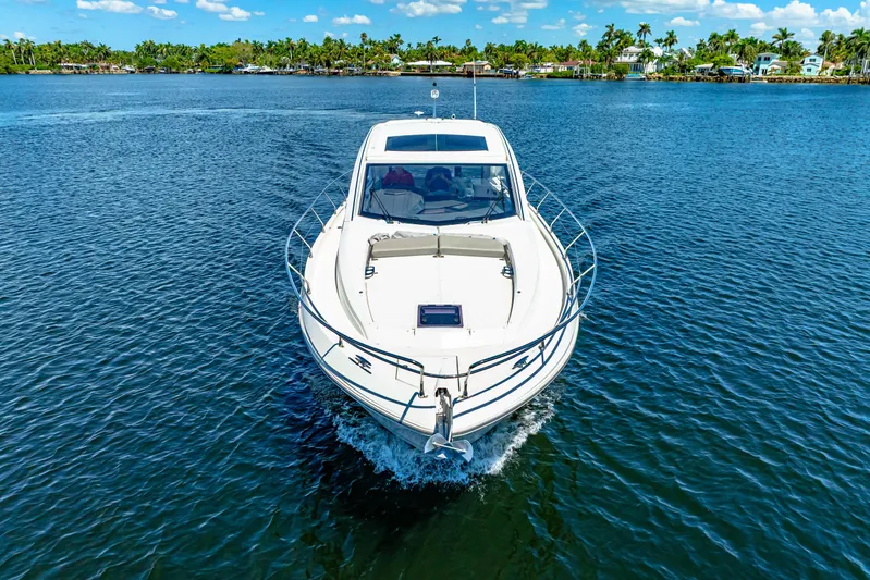  Yacht Photos Pics 2024 Beneteau Gran Turismo 45 yacht cruising on a serene lake with lush shoreline.