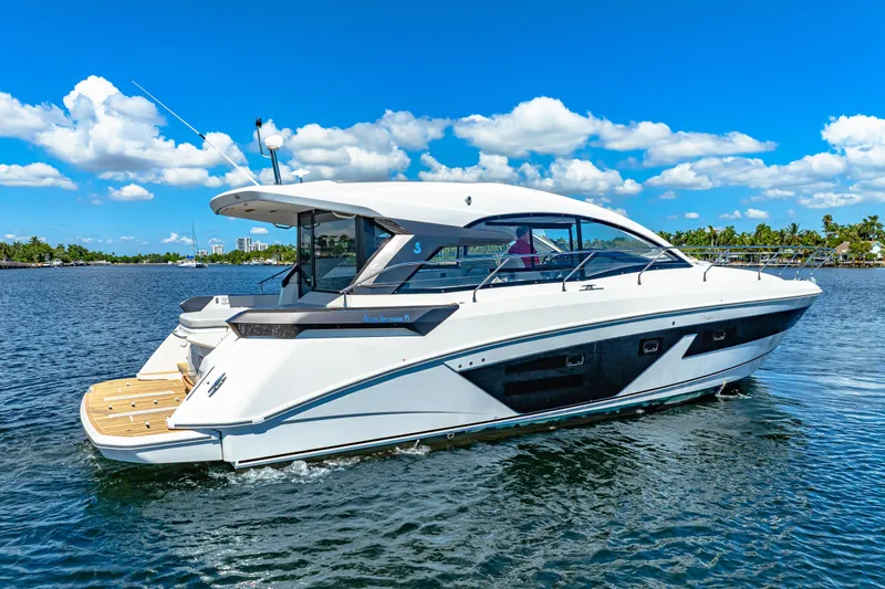  Yacht Photos Pics 2024 Beneteau Gran Turismo 45 yacht cruising on a sunny day, blue sky, calm waters.