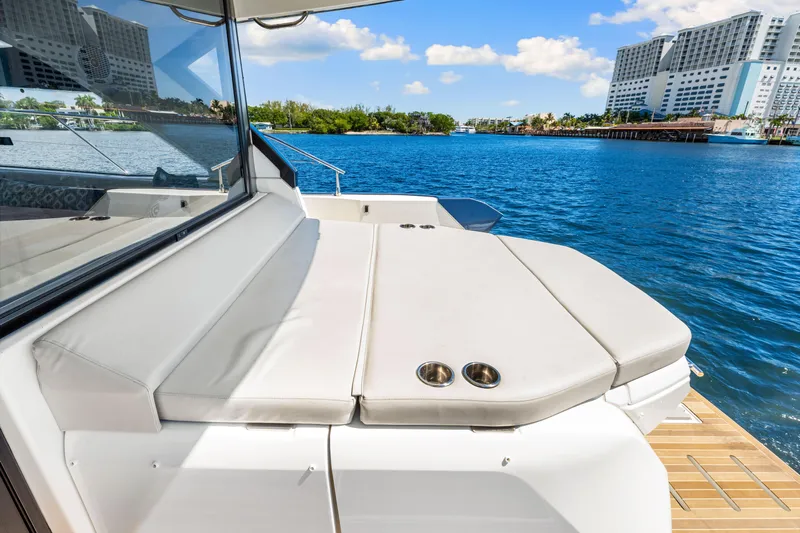  Yacht Photos Pics 2024 Beneteau Gran Turismo 45 yacht with luxurious deck seating, overlooking serene waterfront.