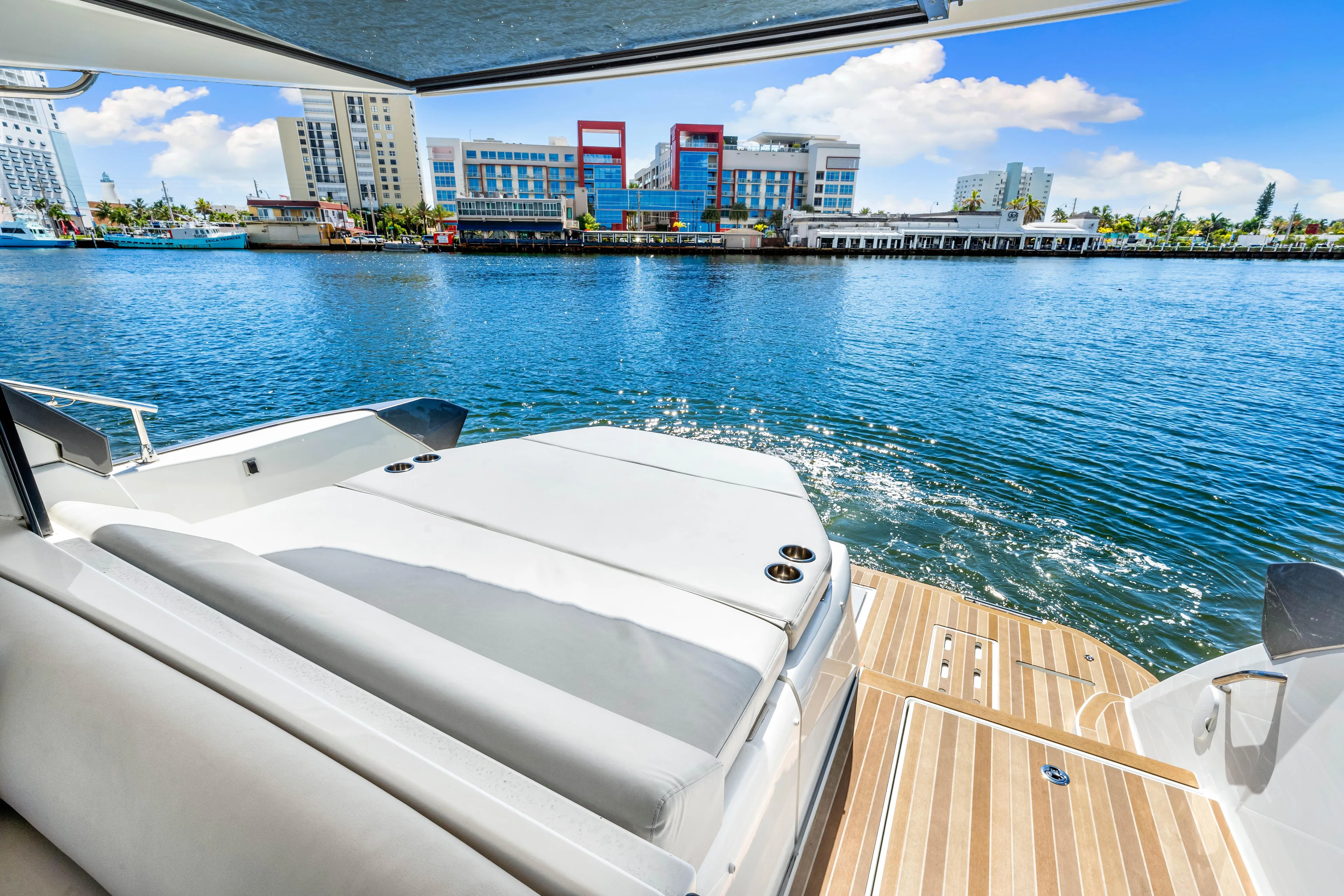  Yacht Photos Pics 2024 Beneteau Gran Turismo 45 yacht with waterfront city view, featuring luxurious deck seating.