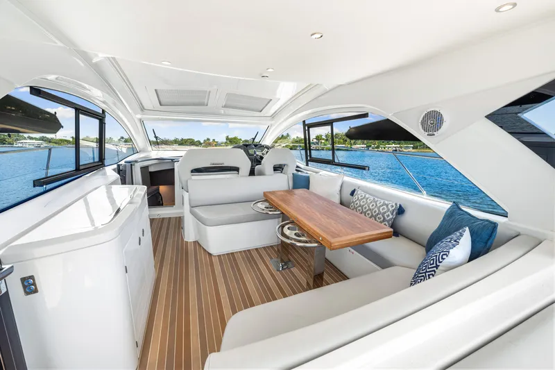  Yacht Photos Pics Luxurious interior of 2024 Beneteau Gran Turismo 45 yacht with elegant seating and wooden table.