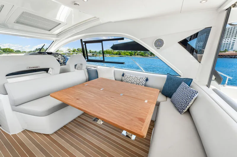  Yacht Photos Pics Luxurious interior of 2024 Beneteau Gran Turismo 45 yacht with elegant seating and wooden table.