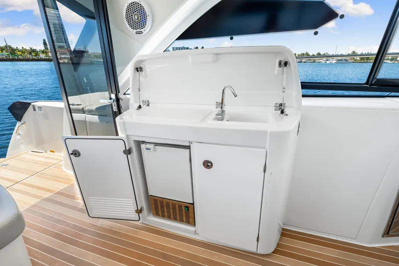  Yacht Photos Pics 2024 Beneteau Gran Turismo 45 yacht kitchenette with sink and storage, overlooking water.