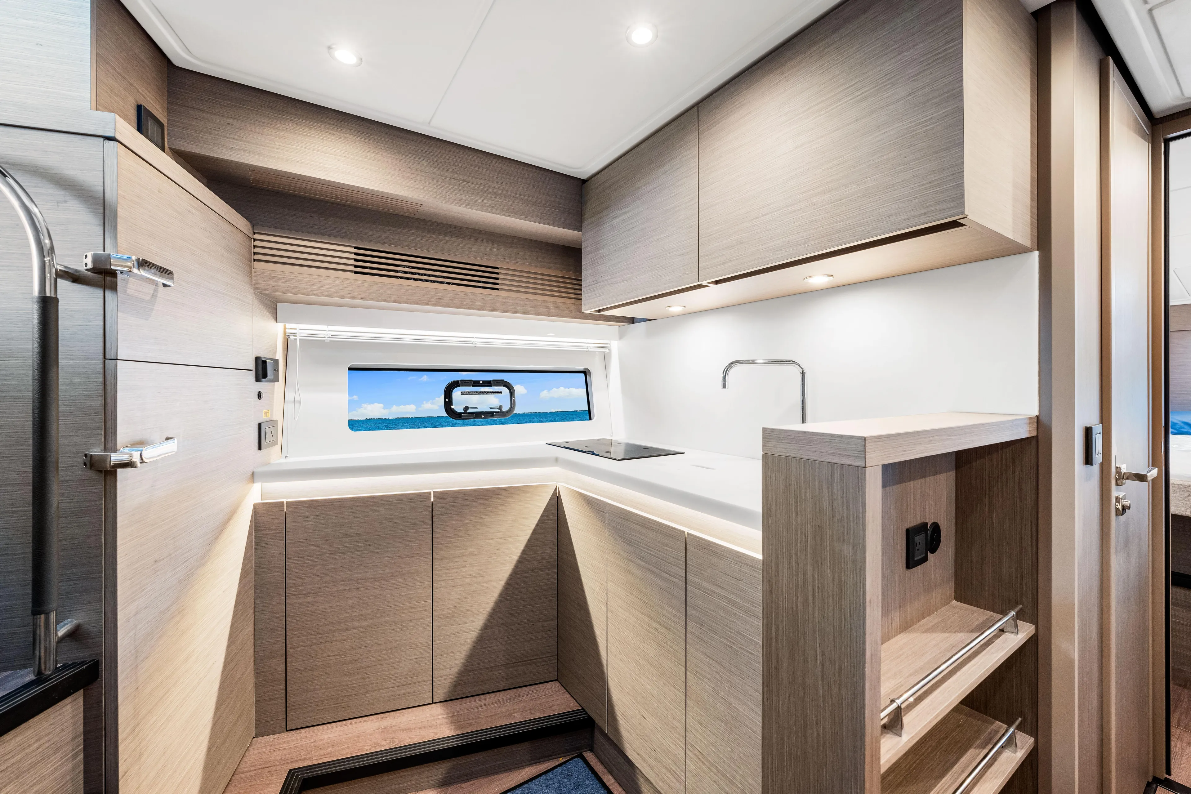  Yacht Photos Pics Modern kitchen interior of 2024 Beneteau Gran Turismo 45 yacht, featuring sleek cabinetry and ocean view.