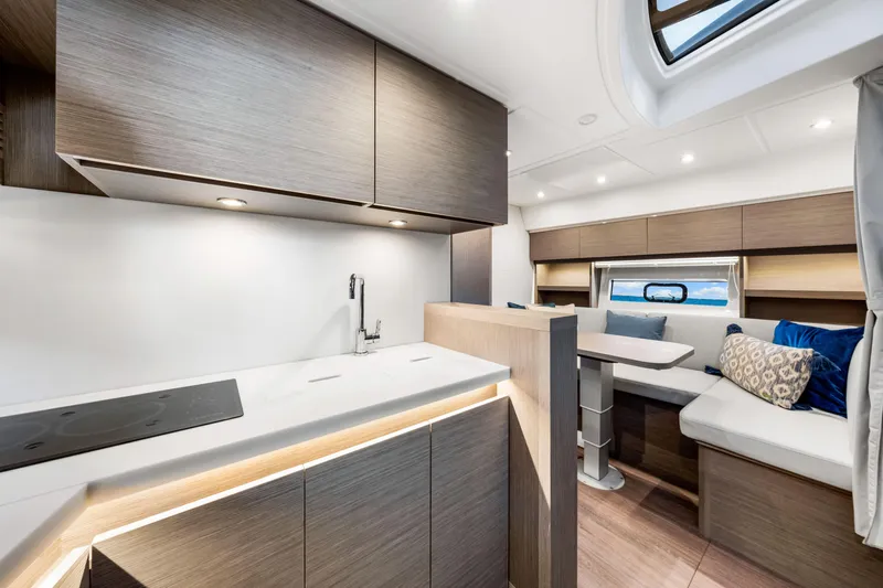  Yacht Photos Pics Luxurious interior of 2024 Beneteau Gran Turismo 45 yacht with modern kitchen and seating area.
