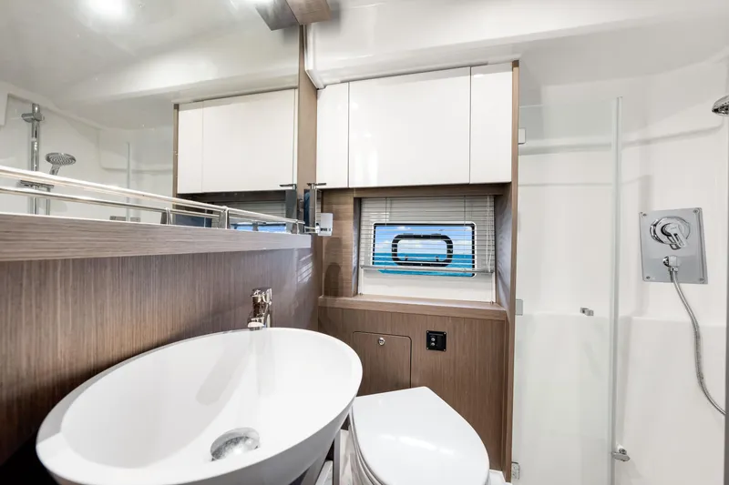  Yacht Photos Pics Luxurious bathroom in 2024 Beneteau Gran Turismo 45 yacht, featuring modern fixtures and elegant design.