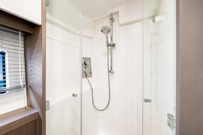  Yacht Photos Pics Modern shower in 2024 Beneteau Gran Turismo 45 yacht, featuring sleek glass doors and chrome fixtures.