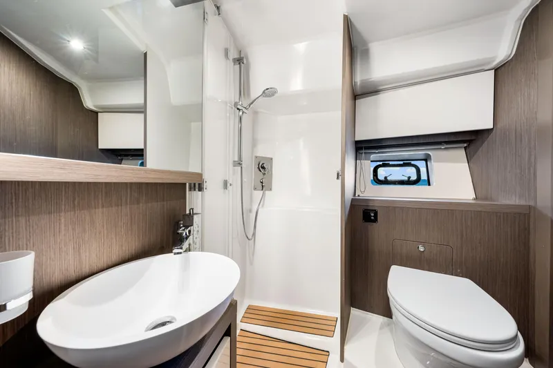  Yacht Photos Pics Luxurious bathroom in 2024 Beneteau Gran Turismo 45 yacht, featuring modern fixtures and elegant design.