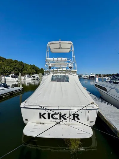  Yacht Photos Pics 2006 Rampage 33 Express boat docked, covered, with clear blue sky background.