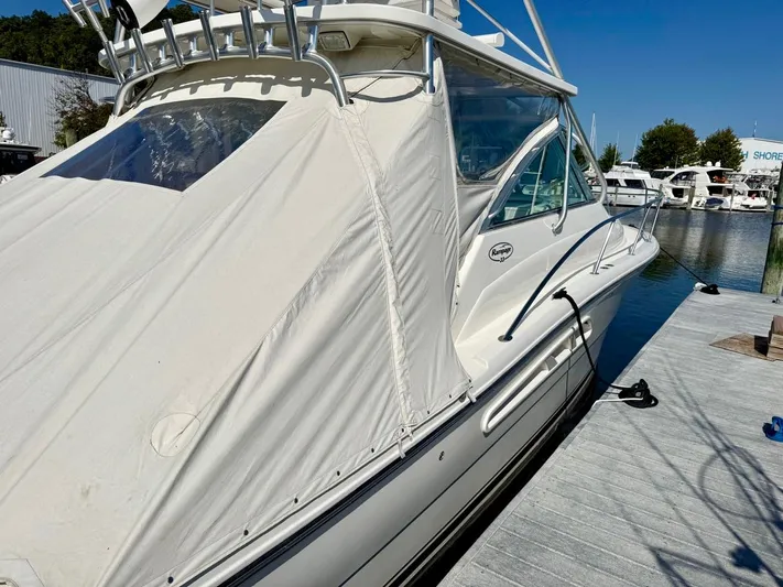  Yacht Photos Pics 2006 Rampage 33 Express boat docked at marina, covered with white tarp.