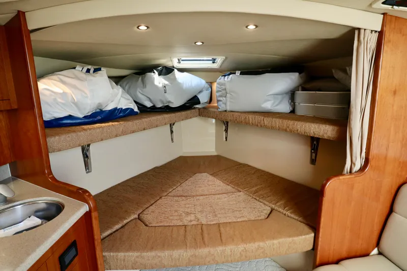  Yacht Photos Pics 2006 Rampage 33 Express cabin interior with storage and bedding.