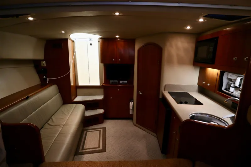  Yacht Photos Pics 2006 Rampage 33 Express interior with kitchenette, seating, and wood cabinetry.
