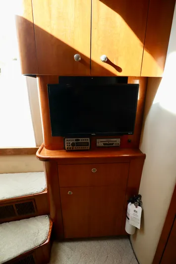  Yacht Photos Pics 2006 Rampage 33 Express interior with TV, wooden cabinets, and carpeted stairs.