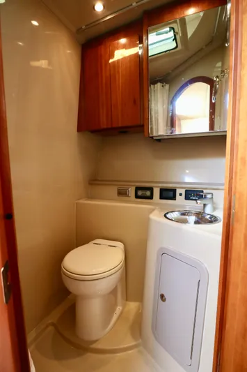  Yacht Photos Pics 2006 Rampage 33 Express boat bathroom with wood cabinets and modern fixtures.