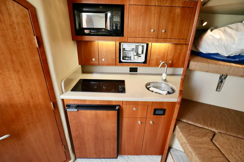  Yacht Photos Pics Compact kitchen area in 2006 Rampage 33 Express boat with microwave, sink, and stove.