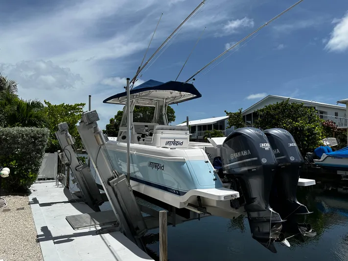  Yacht Photos Pics 2015 Intrepid 327i Open boat with dual Yamaha engines docked on a lift.