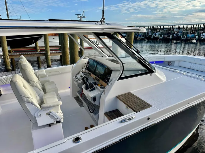  Yacht Photos Pics 2021 Regal 38 SAV boat interior with helm, white seating, and marina backdrop.