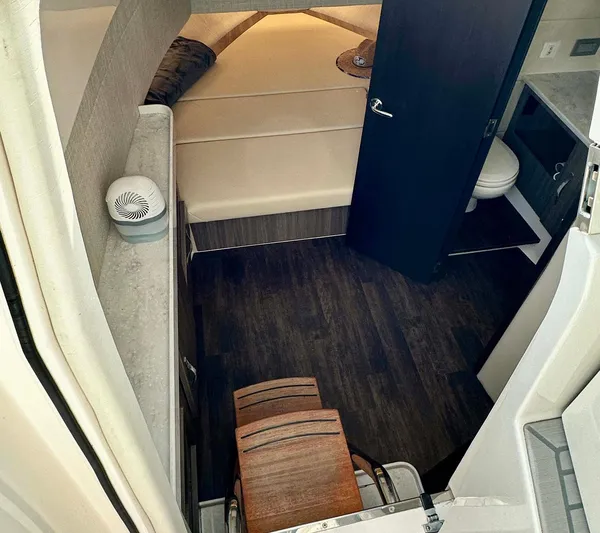  Yacht Photos Pics 2021 Regal 38 SAV cabin interior with bed, dark wood flooring, and compact bathroom.