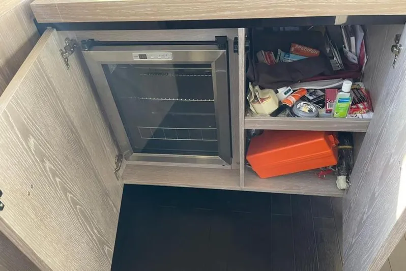  Yacht Photos Pics Open cabinet on Azimut Magellano 66 yacht, showing storage and small fridge, 2019 model.