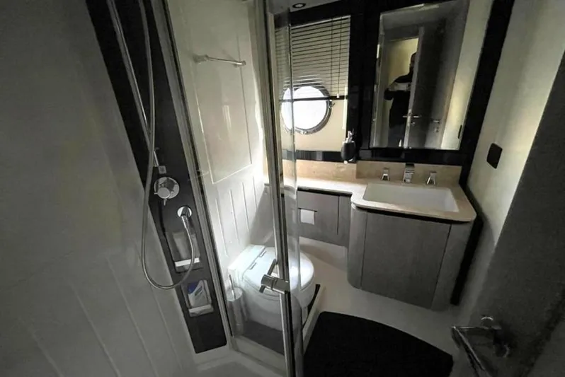  Yacht Photos Pics Luxurious bathroom in 2019 Azimut Magellano 66 yacht with modern fixtures and porthole window.