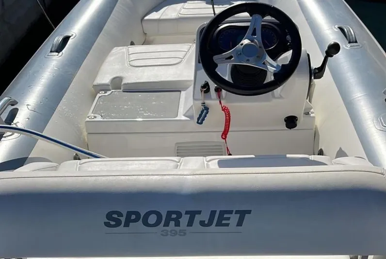  Yacht Photos Pics SportJet 395 inflatable boat interior with steering wheel, white seating, and control panel.