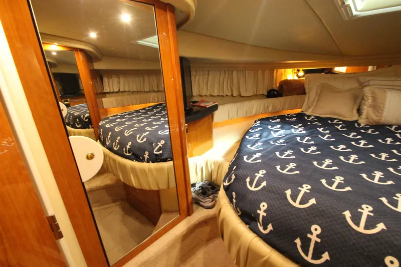 Yacht Photos Pics Luxurious cabin interior of 2000 Sea Ray 410 Sundancer with nautical-themed bedding.